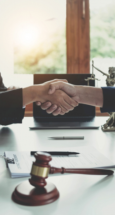 Businessman shaking hands to seal a deal with his partner lawyers or attorneys discussing a contract agreement.